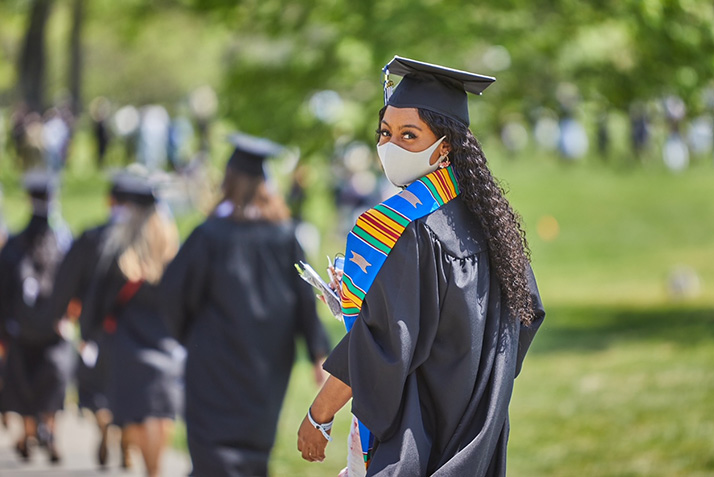 A graduate smiles beneath her mask. 