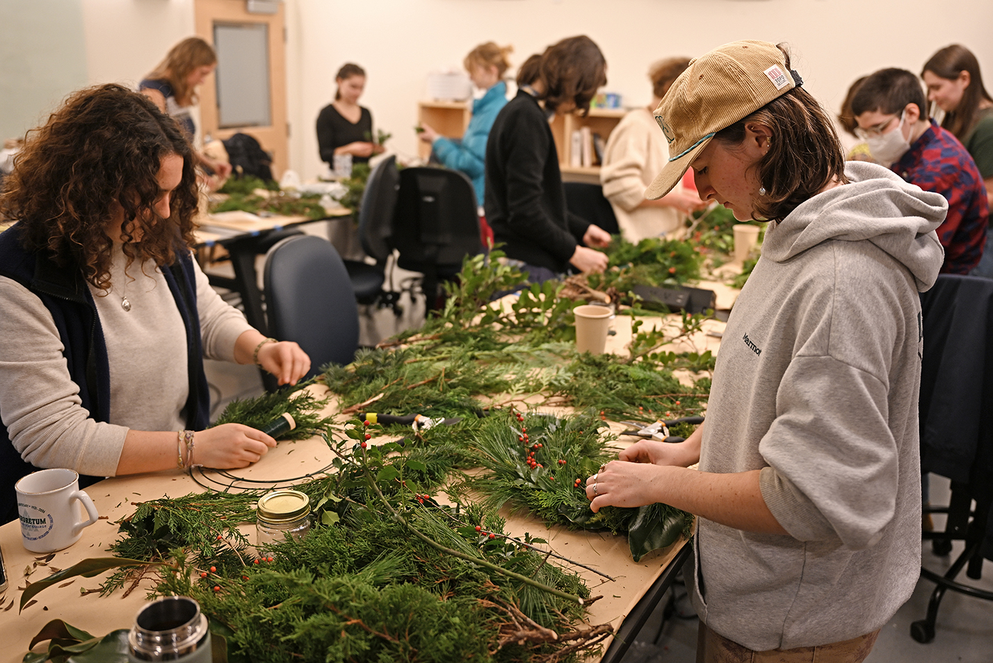 Students work with greens during a wreath making workshop.