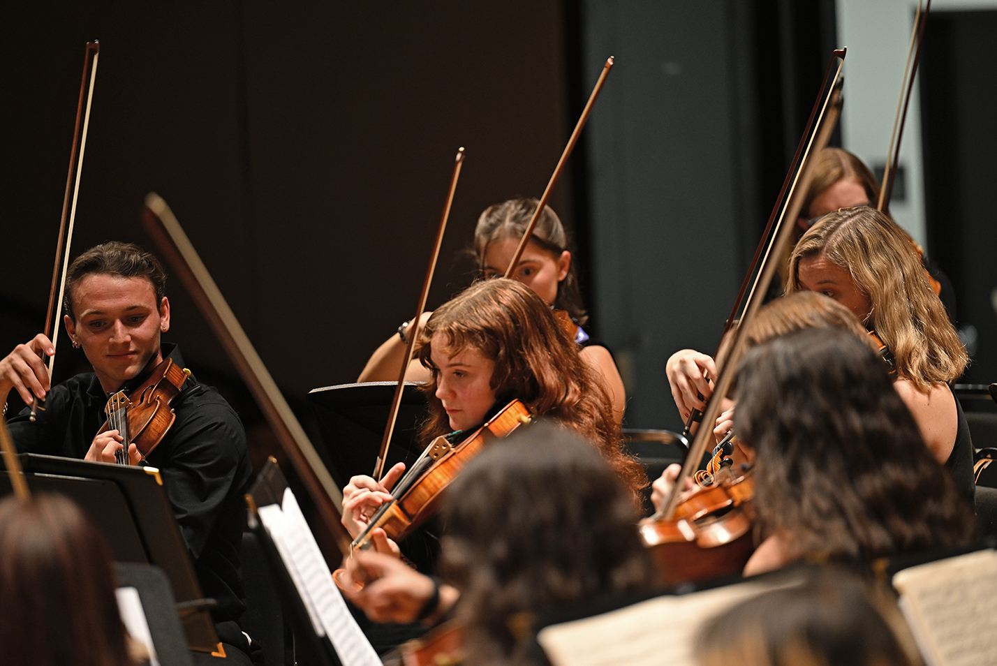 Members of the student orchestra string section play.